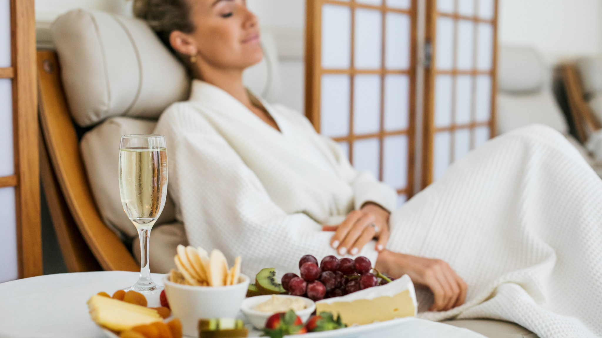 Woman Relaxing With Food Platter And Champagne